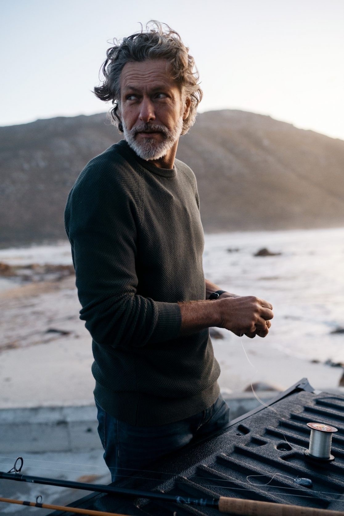 Man by the coast preparing fishing gear