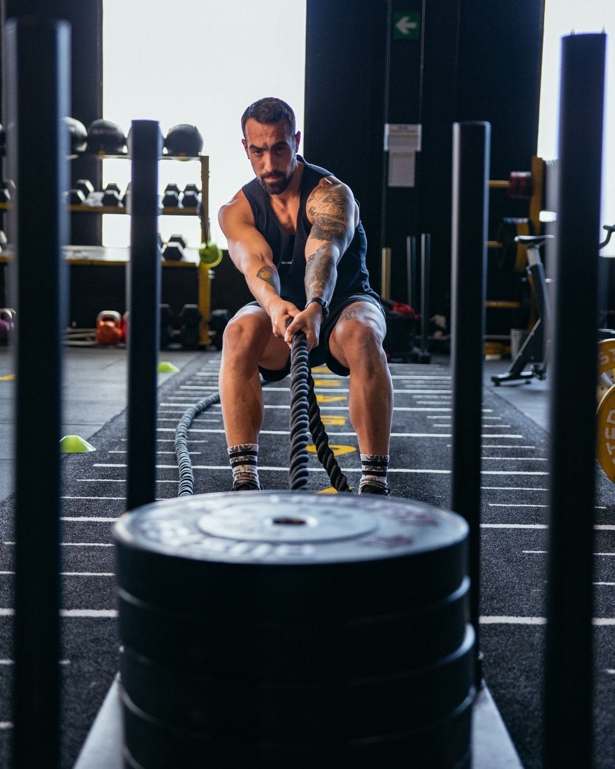 A man working out with battle ropes in a gym