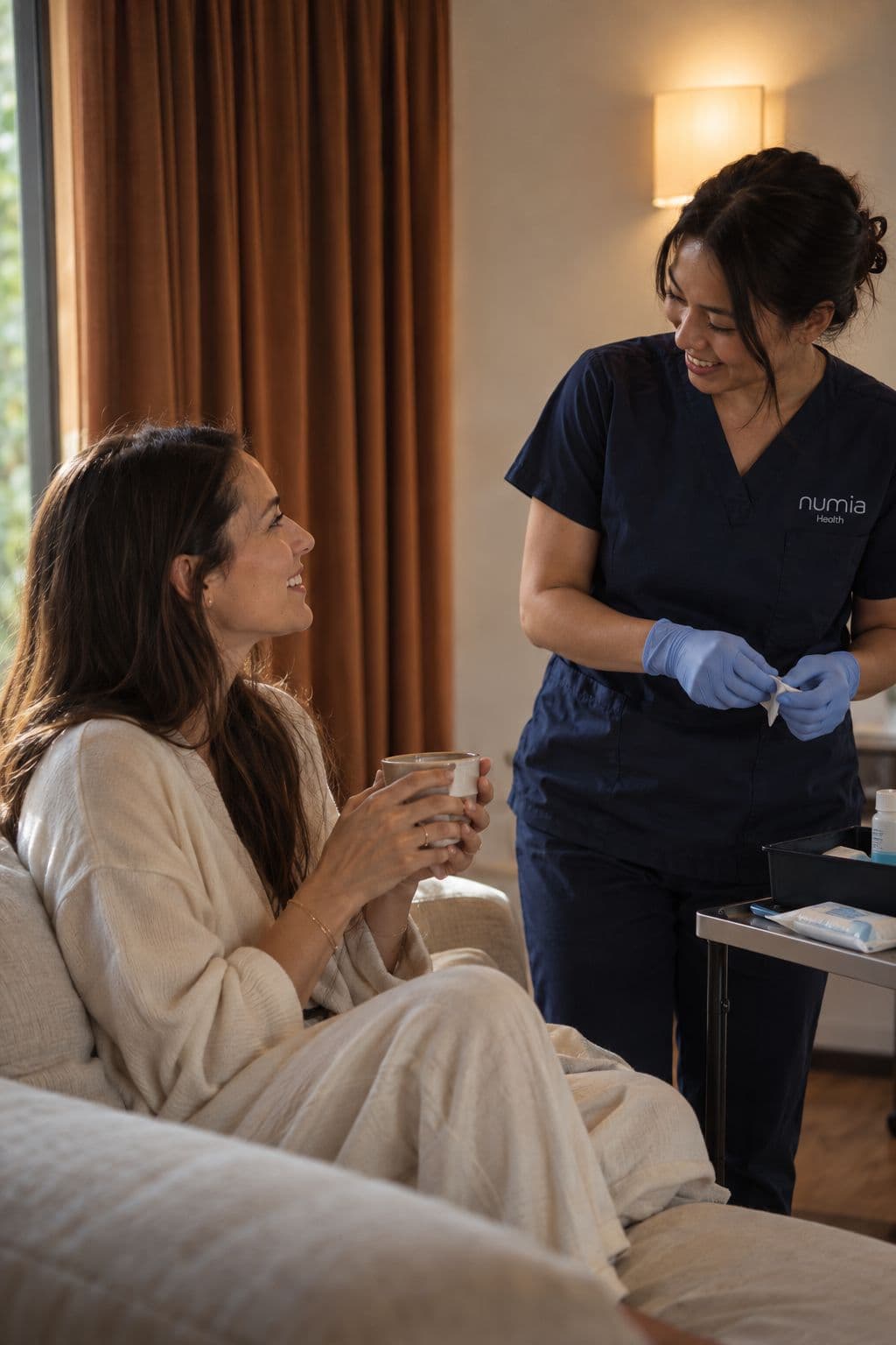 A Numia clinician taking a blood sample from a woman on her sofa at home