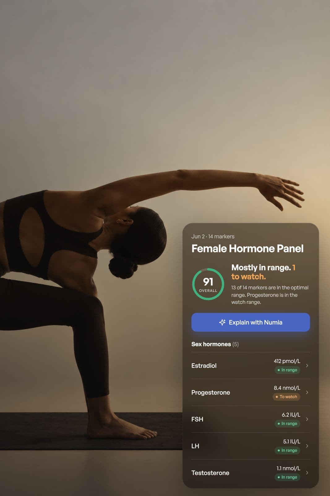 A woman on a yoga mat checking her hormone results on her phone