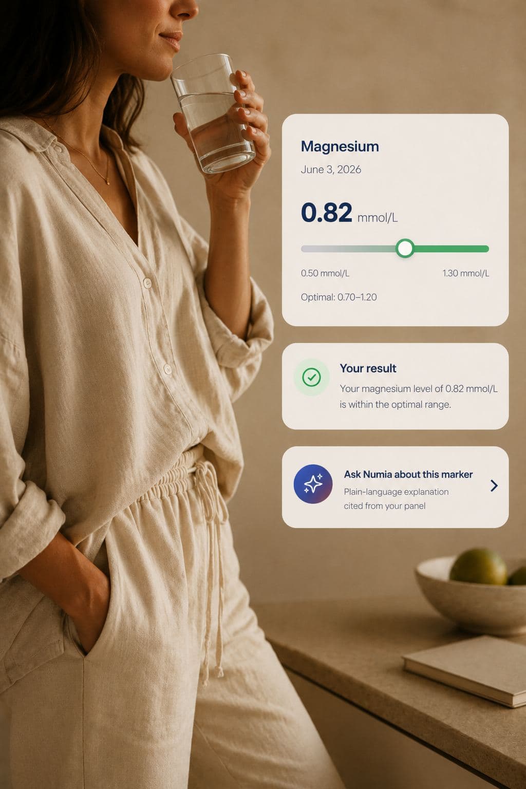 A woman drinking a glass of water at home, with a magnesium result card from the Numia app overlaid